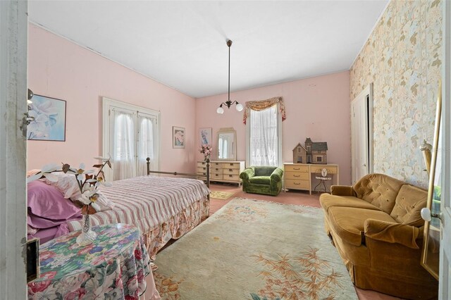 bedroom featuring french doors, hardwood / wood-style floors, and a chandelier