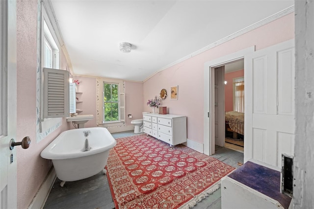 bathroom with vanity, hardwood / wood-style flooring, crown molding, a bathtub, and lofted ceiling