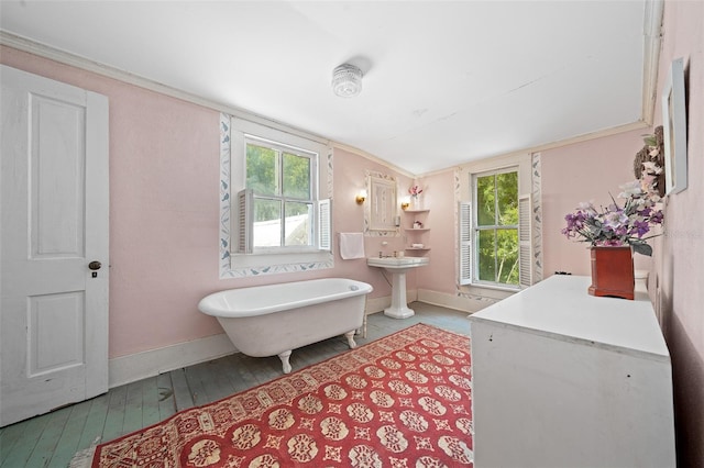 bathroom featuring vaulted ceiling, a washtub, wood-type flooring, and a healthy amount of sunlight