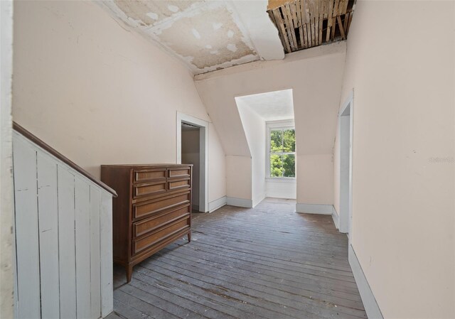 corridor featuring lofted ceiling and hardwood / wood-style floors