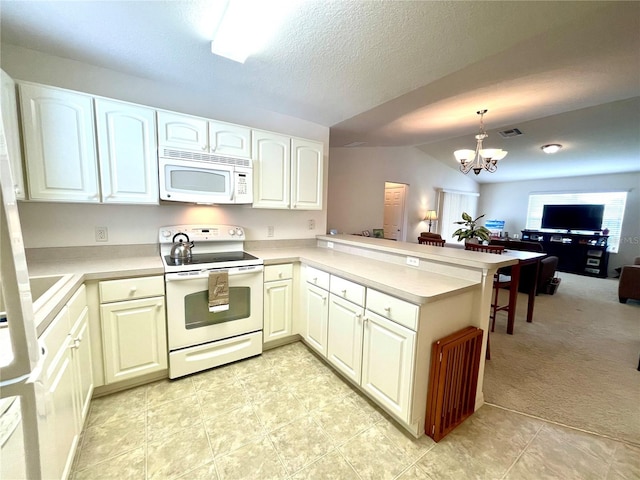 kitchen with light colored carpet, white appliances, hanging light fixtures, and kitchen peninsula