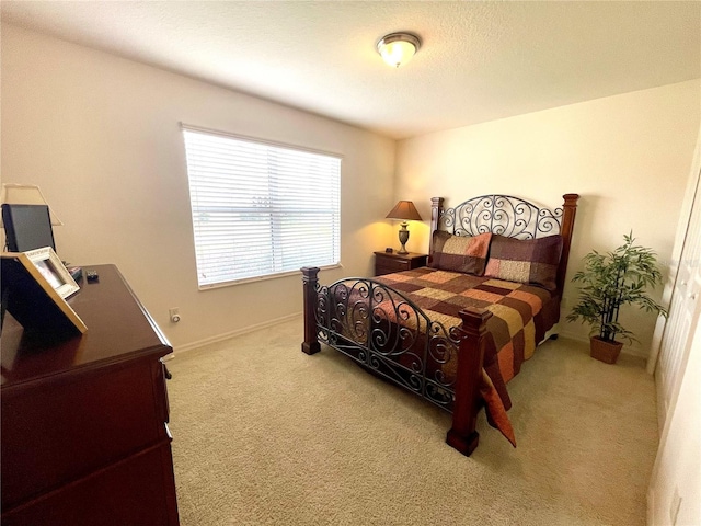 bedroom featuring light carpet and baseboards