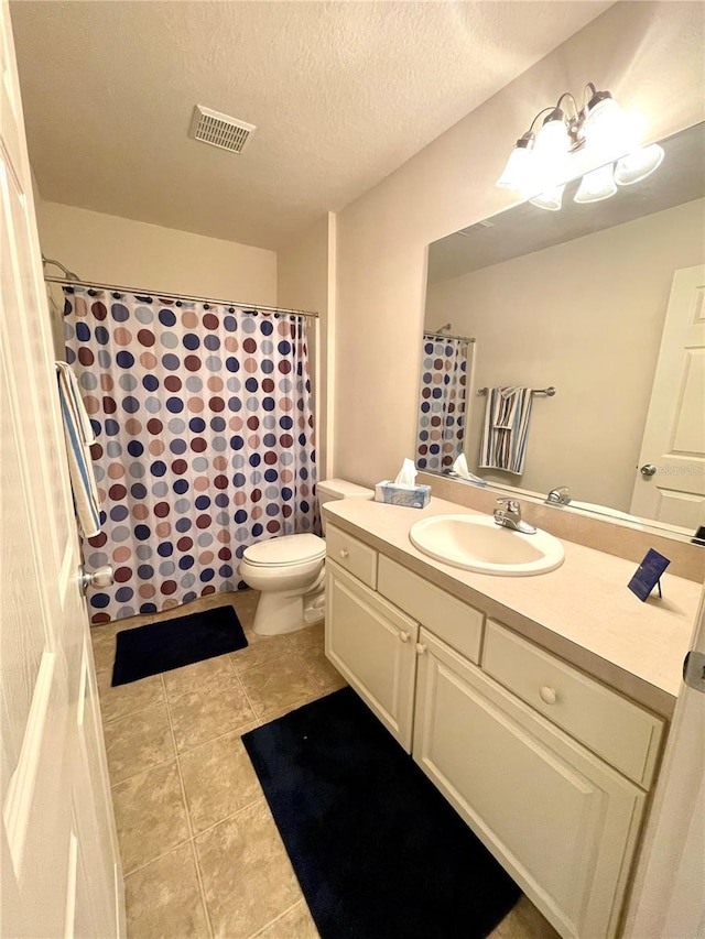 bathroom featuring a textured ceiling, toilet, visible vents, vanity, and tile patterned floors