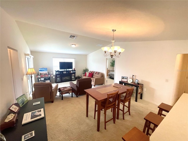 carpeted dining area with lofted ceiling and a chandelier