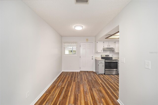 kitchen featuring stainless steel electric stove, dark wood-type flooring, and a textured ceiling