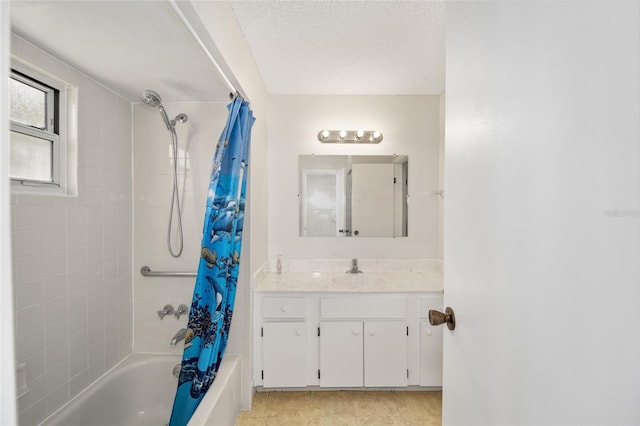 bathroom with a textured ceiling, vanity, and shower / tub combo