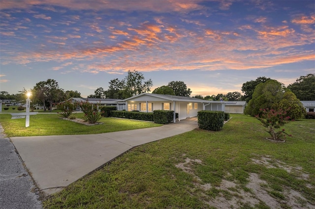 ranch-style home with driveway and a front lawn