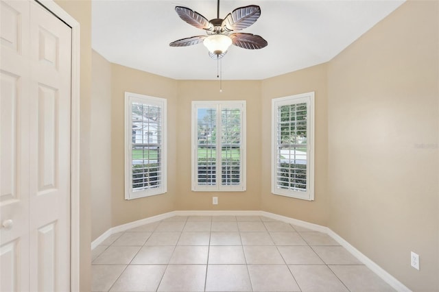 tiled spare room featuring ceiling fan