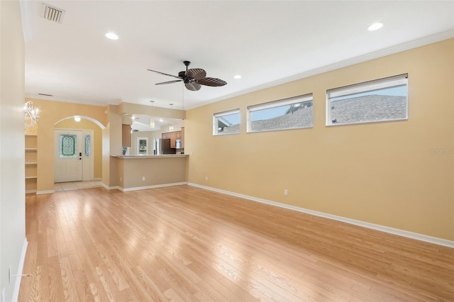 interior space featuring ceiling fan with notable chandelier, crown molding, and light hardwood / wood-style flooring