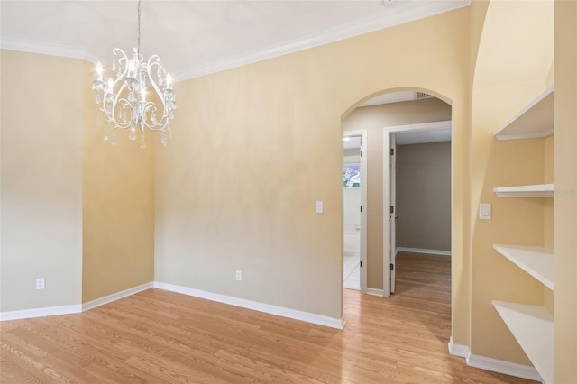 empty room featuring light wood-type flooring, crown molding, and a notable chandelier