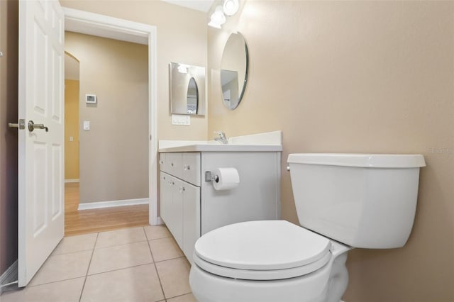 bathroom featuring tile patterned flooring, toilet, and vanity