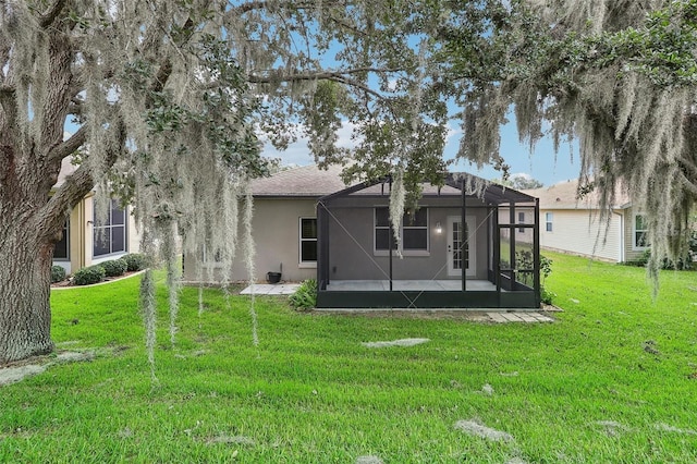 rear view of house featuring a yard and a lanai