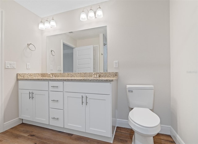 bathroom with hardwood / wood-style floors, toilet, and vanity