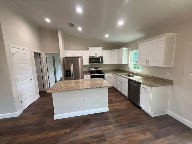 kitchen with a center island, sink, appliances with stainless steel finishes, white cabinets, and light stone counters