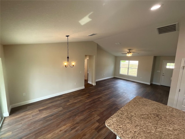 interior space with ceiling fan with notable chandelier, dark hardwood / wood-style floors, and lofted ceiling