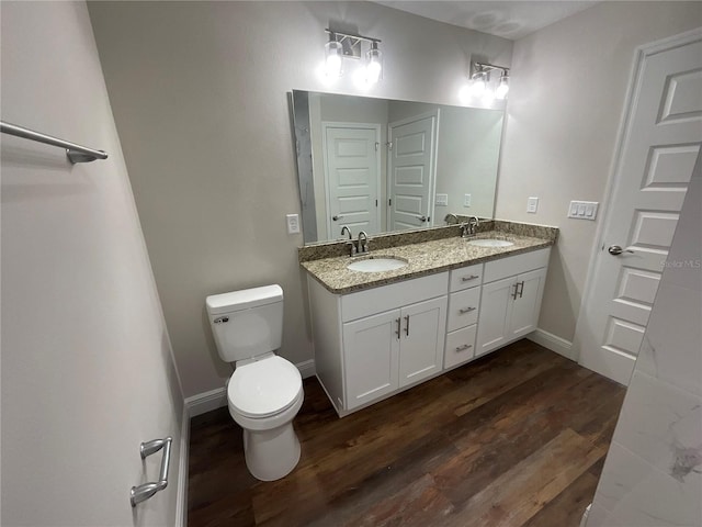 bathroom with toilet, vanity, and hardwood / wood-style flooring