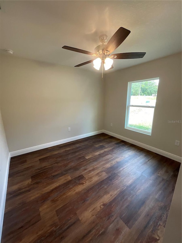 empty room featuring ceiling fan and dark hardwood / wood-style flooring