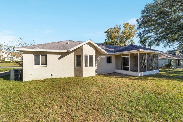 rear view of property with a lawn, a sunroom, and central air condition unit