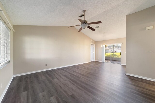 empty room featuring lofted ceiling, ceiling fan with notable chandelier, dark wood-type flooring, and a textured ceiling