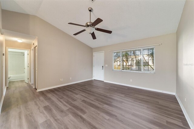 empty room featuring wood-type flooring, lofted ceiling, a textured ceiling, and ceiling fan