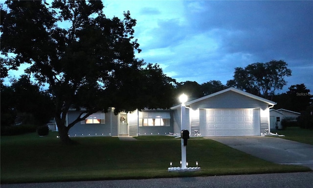 ranch-style home featuring a garage and a front lawn