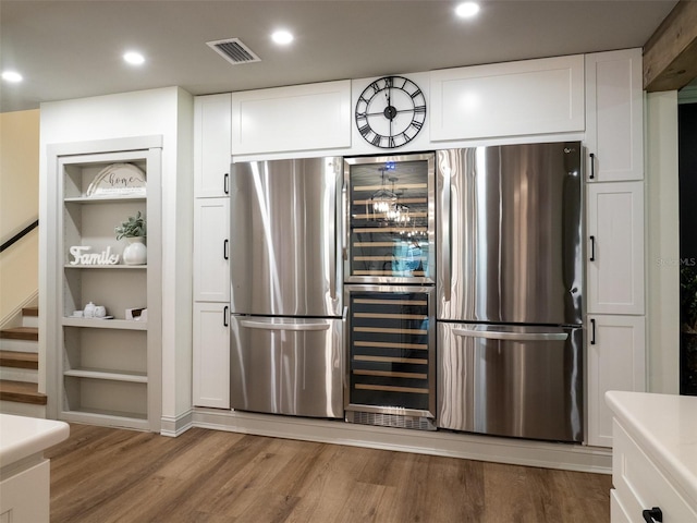 kitchen featuring light hardwood / wood-style flooring, white cabinetry, and stainless steel refrigerator