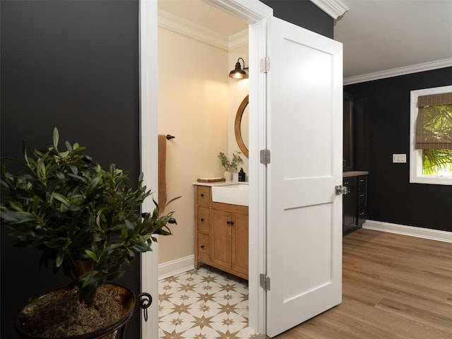 bathroom with ornamental molding, vanity, and wood-type flooring