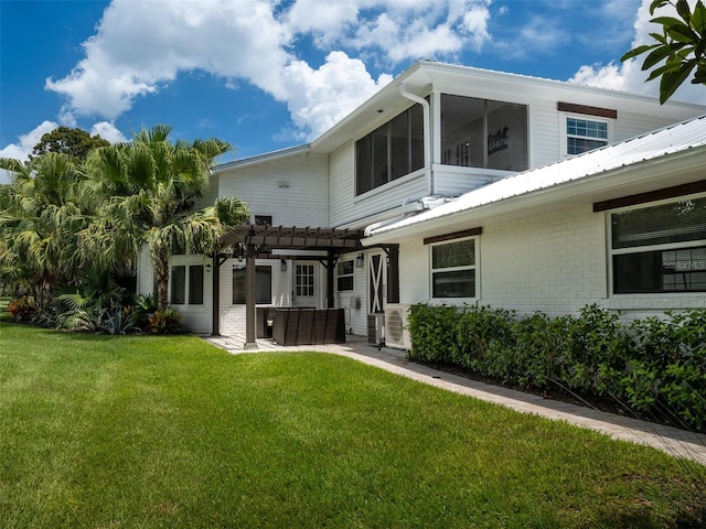 rear view of property with a pergola, a lawn, and a patio