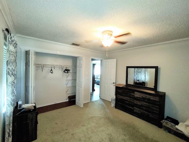 carpeted bedroom with ceiling fan, a closet, and a textured ceiling