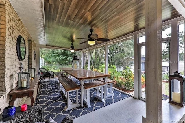 sunroom featuring ceiling fan and wooden ceiling