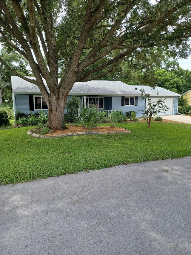 ranch-style home with a garage, a front yard, and concrete driveway