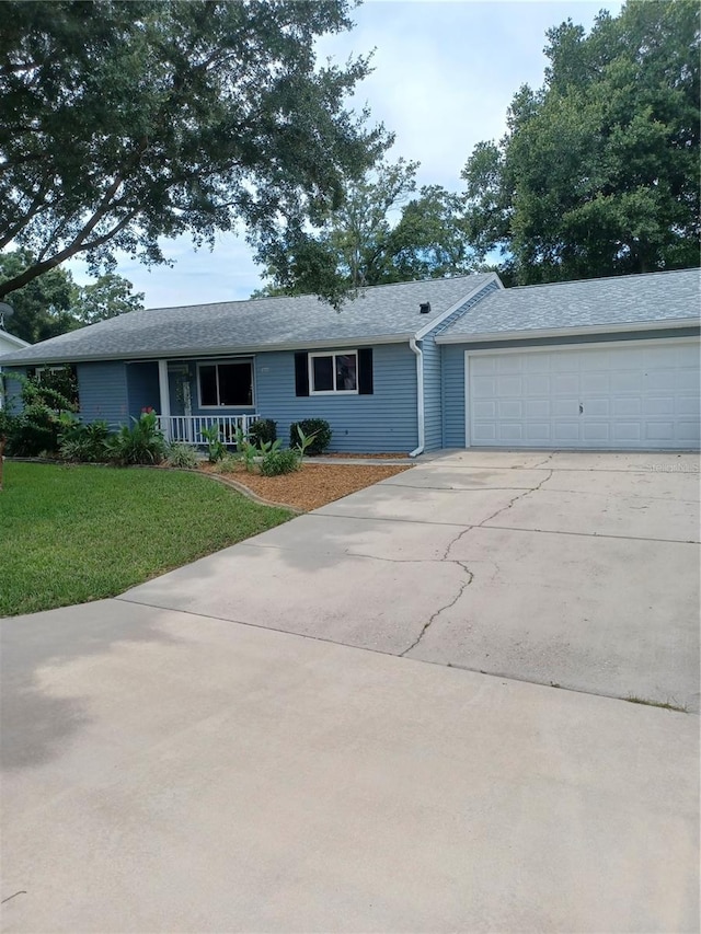 ranch-style home with a garage, a porch, concrete driveway, and a front yard