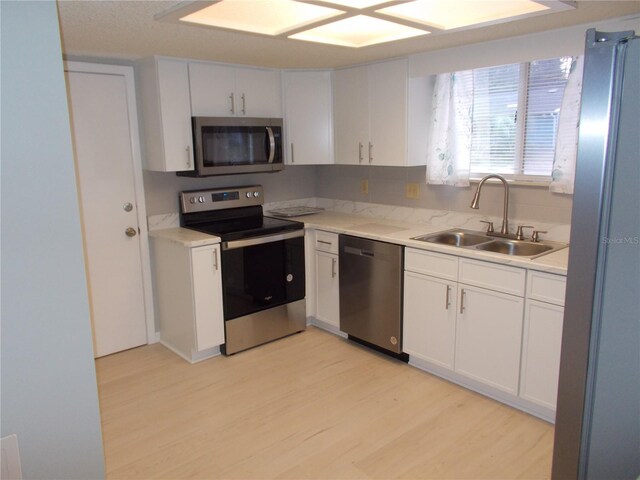 kitchen featuring light hardwood / wood-style flooring, stainless steel appliances, sink, and white cabinetry