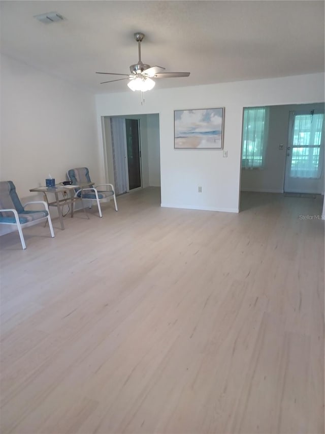 unfurnished room featuring baseboards, light wood finished floors, visible vents, and a ceiling fan