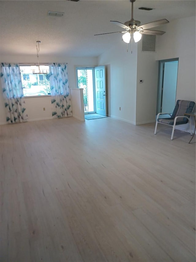 unfurnished living room featuring ceiling fan and light wood-type flooring