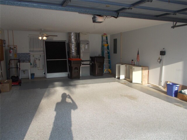 garage featuring electric panel, heating unit, ceiling fan, a garage door opener, and water heater