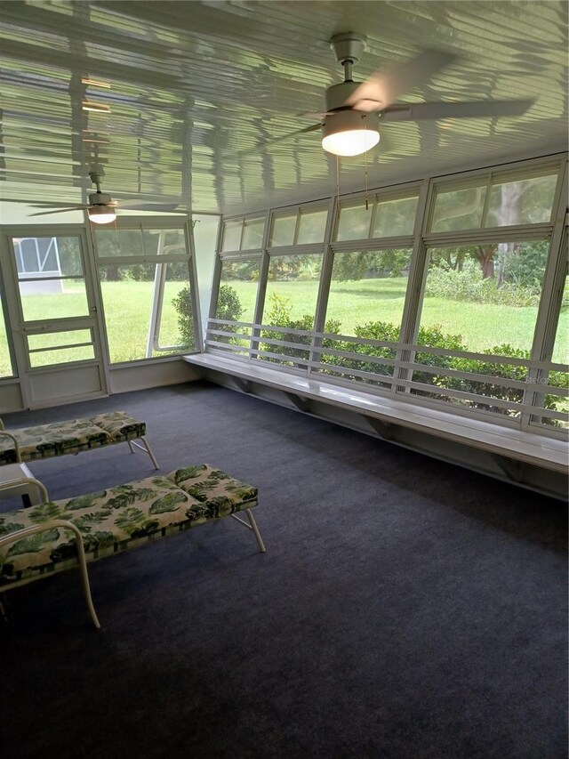 unfurnished sunroom with ceiling fan