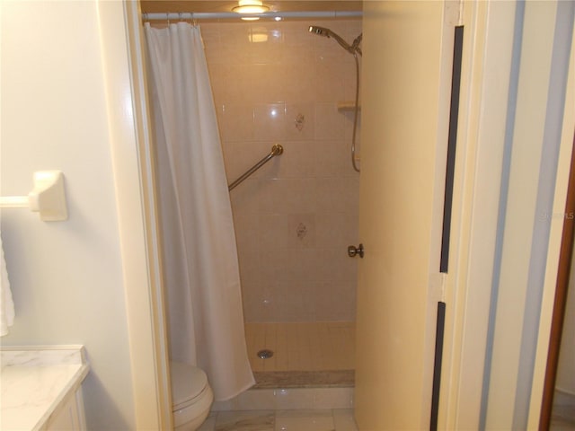 bathroom featuring toilet, a stall shower, and vanity