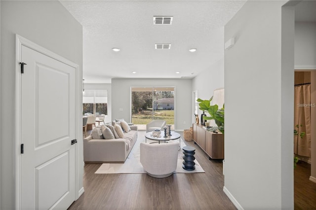 living room with dark wood-type flooring and a textured ceiling