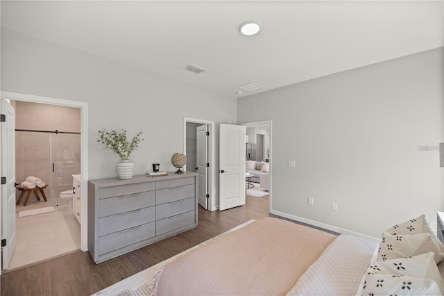 bedroom featuring ensuite bathroom and dark wood-type flooring