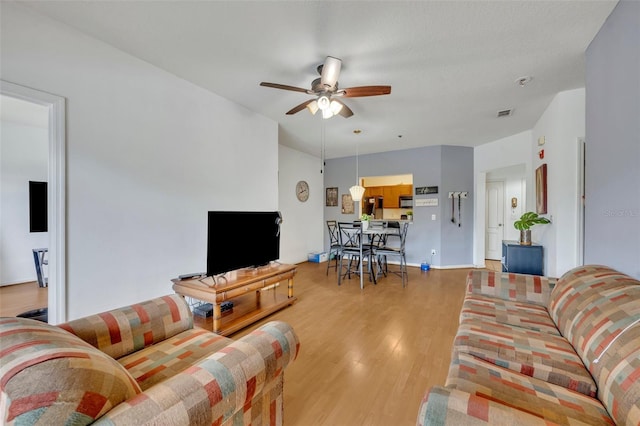 living room with ceiling fan and light wood-type flooring