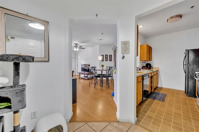 kitchen with ceiling fan, dishwashing machine, pendant lighting, black fridge, and light tile patterned floors