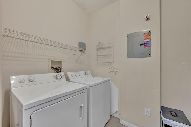 clothes washing area with washer and clothes dryer and electric panel