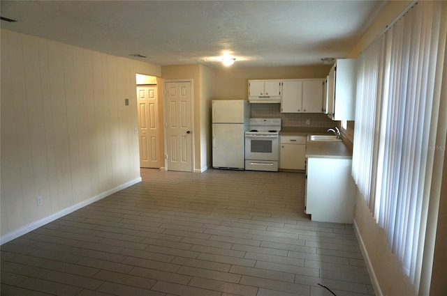 kitchen featuring decorative backsplash, white appliances, sink, and white cabinets