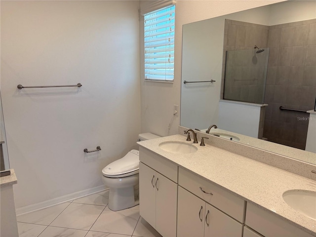 bathroom featuring a tile shower, vanity, toilet, and tile patterned floors