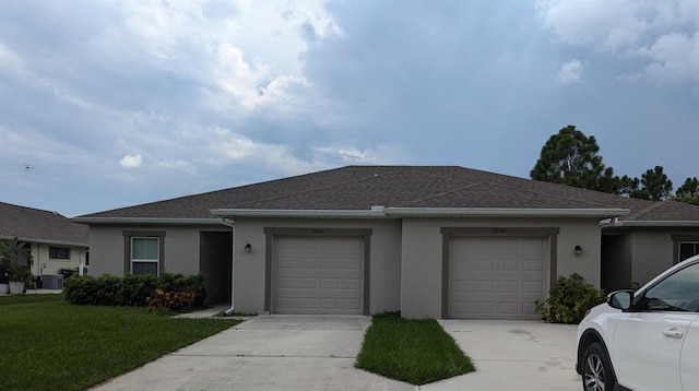 single story home featuring a garage and a front lawn