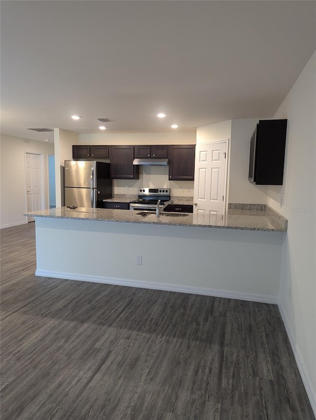 kitchen with dark hardwood / wood-style floors, appliances with stainless steel finishes, stone counters, kitchen peninsula, and dark brown cabinets