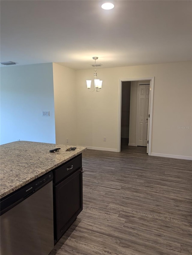 kitchen with a notable chandelier, dark hardwood / wood-style flooring, light stone counters, stainless steel dishwasher, and pendant lighting