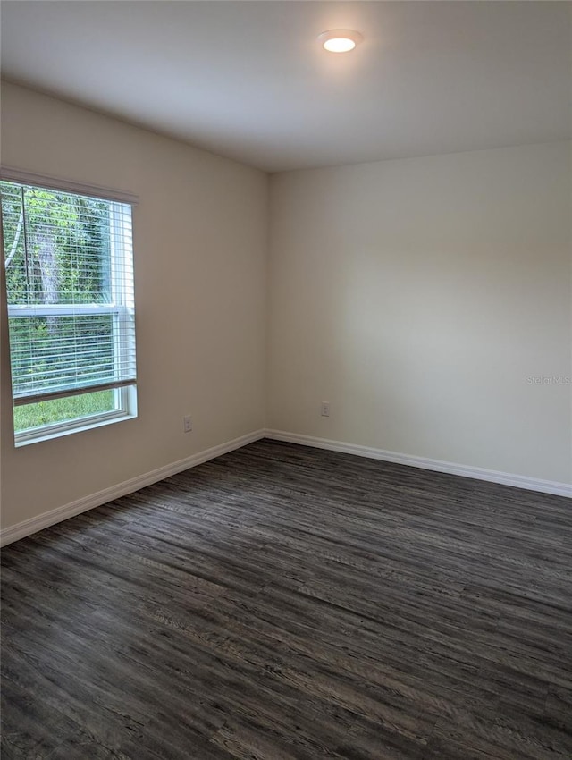 spare room featuring dark wood-type flooring