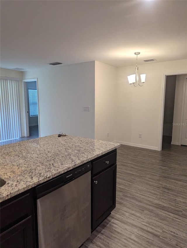 kitchen featuring light stone counters, pendant lighting, an inviting chandelier, stainless steel dishwasher, and dark hardwood / wood-style floors